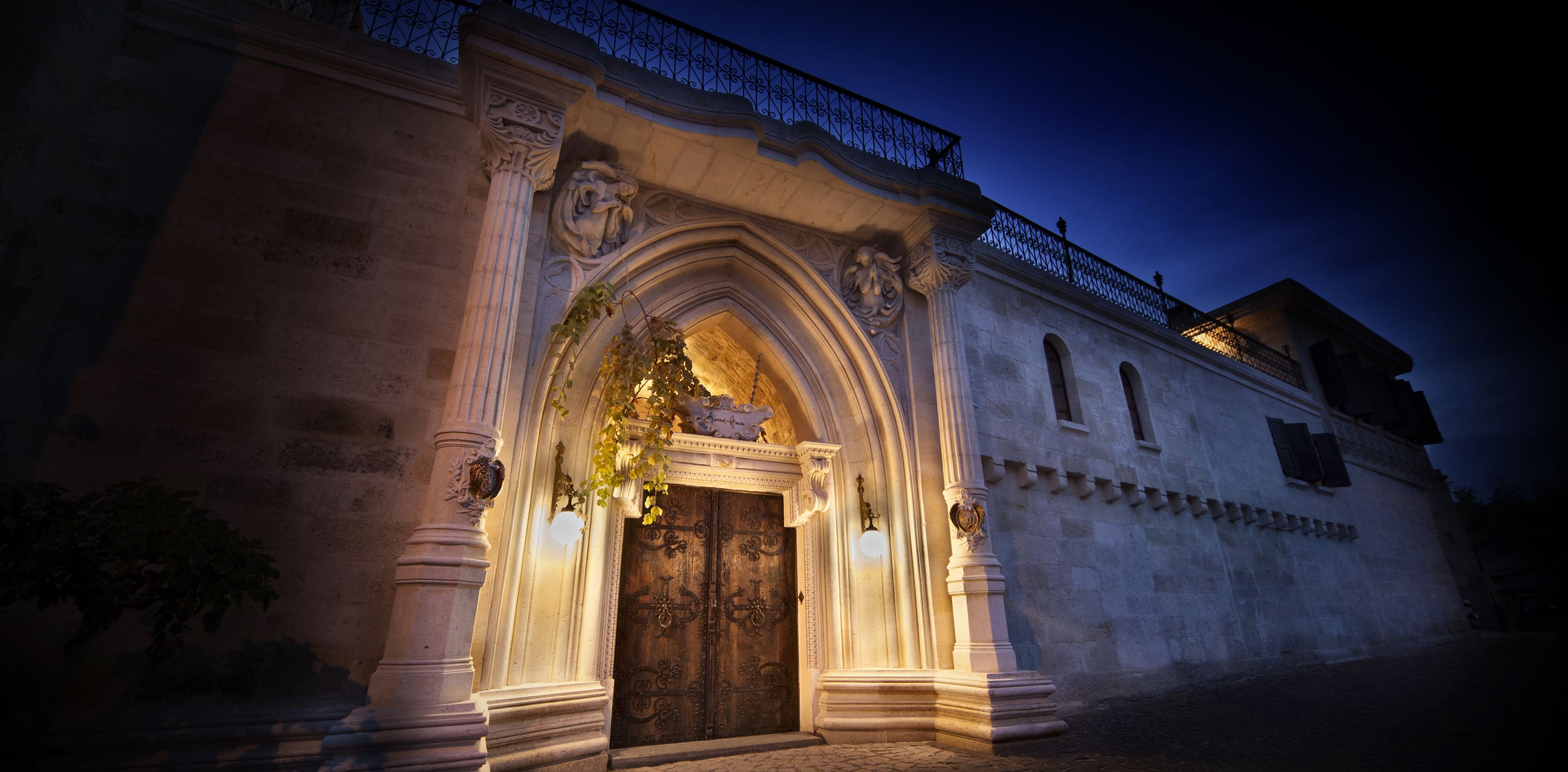 Un edificio histórico con arquitectura ornamentada, que incluye una gran entrada en arco y columnas decorativas.