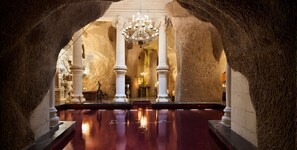 An interior with a reflective pool, white columns, and a chandelier.