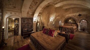 Quarto com uma cama grande, móveis de madeira e parede de pedra.
