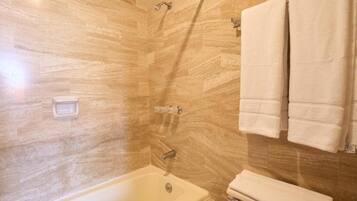 Een badkamer met een bad, toilet en douche, inclusief een handdoekhouder.