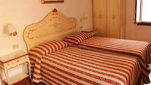 A bedroom with two beds, a bedside table, a lamp, and a wardrobe. - Bed & Breakfast Barababao (Venice)