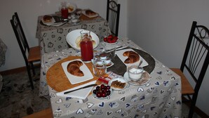 A dining table with a patterned tablecloth, plates of food, and various condiments. - Bed & Breakfast Barababao (Venice)