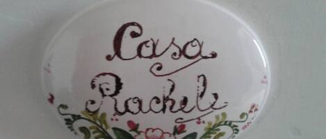 A white ceramic object with the name "Casa Rachel" and floral designs.