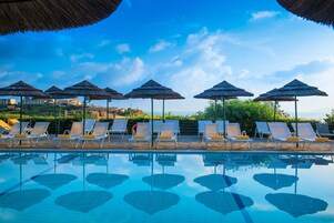 Una piscina al aire libre de temporada, sombrillas