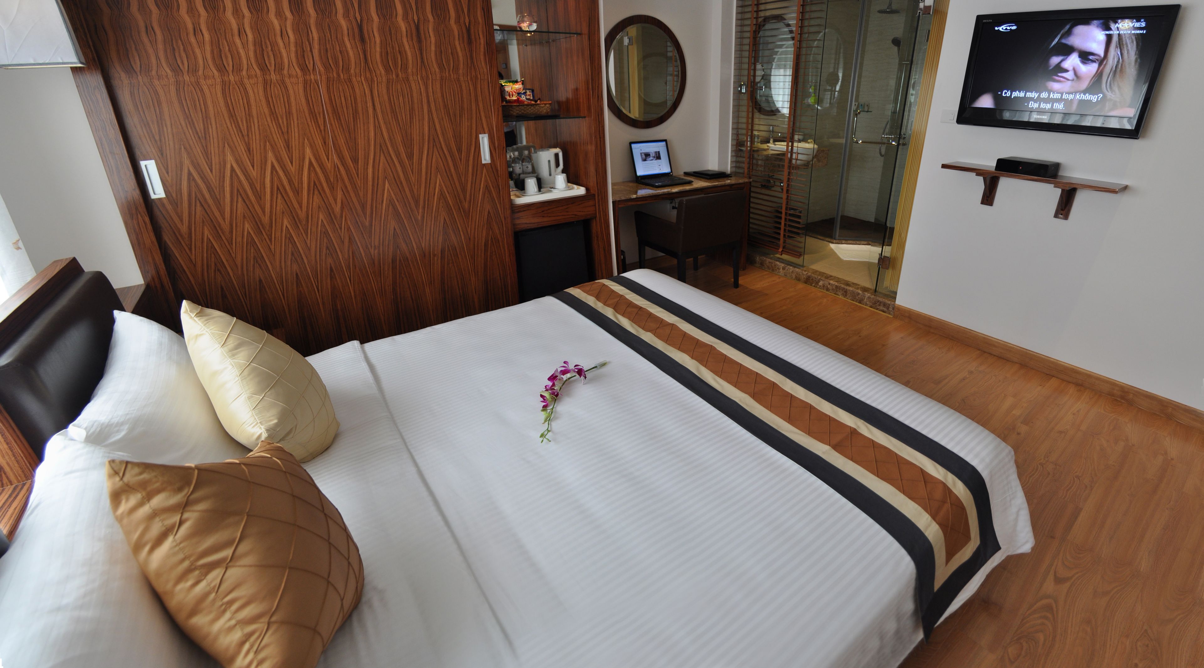 Ein Hotelzimmer mit Bett, Schreibtisch, Fernseher und Duschbereich.