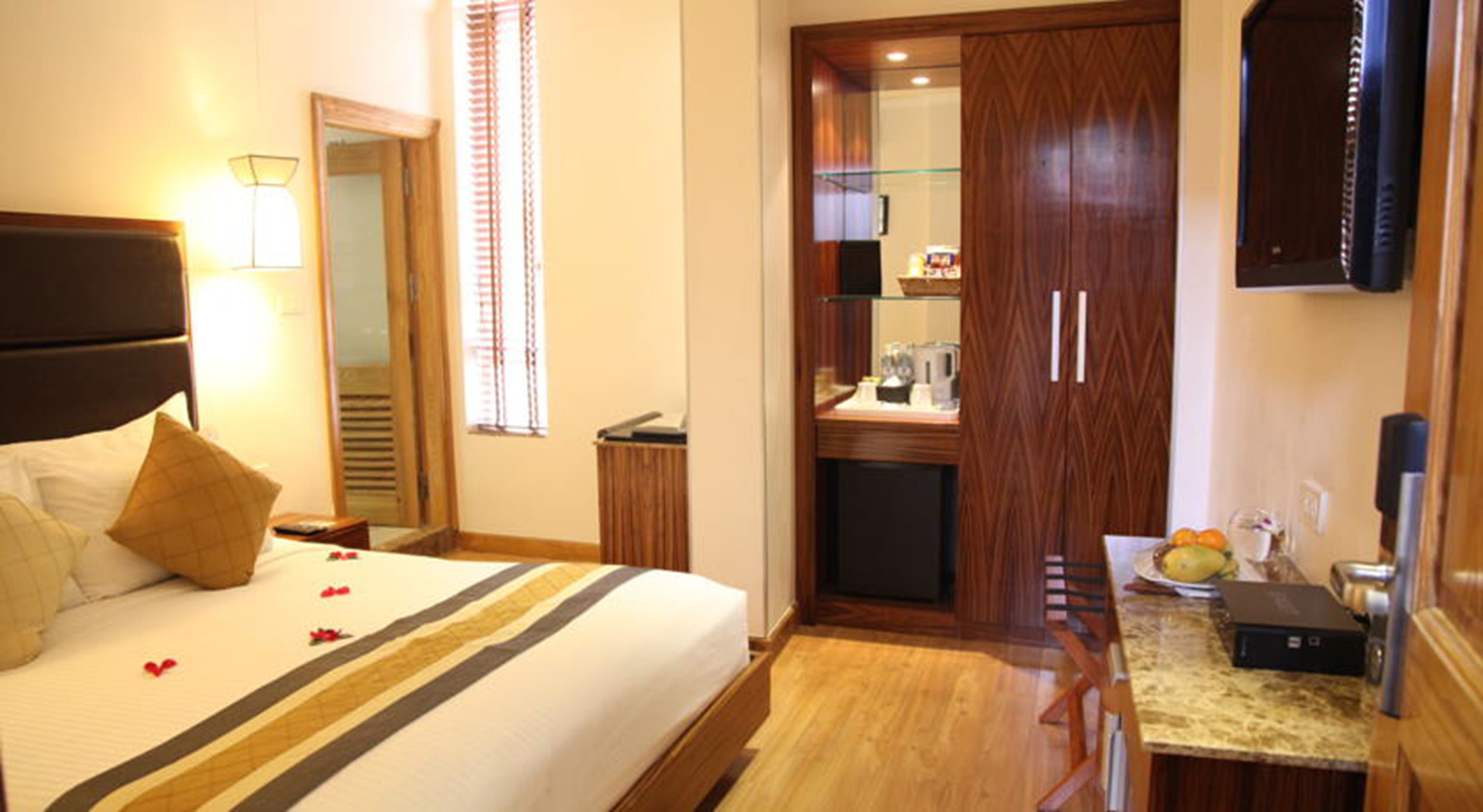 Een hotelkamer met een bed, een bureau, een spiegel en een kledingkast.