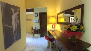 A hallway with a painting, a lamp, a mirror, and a vase with flowers. - Perseo B&B (Rome)