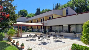 A courtyard with outdoor seating, potted plants, and a covered area. - Pennile (Ascoli Piceno)