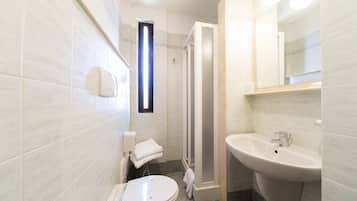 Un bagno moderno con toilette, lavandino e doccia.