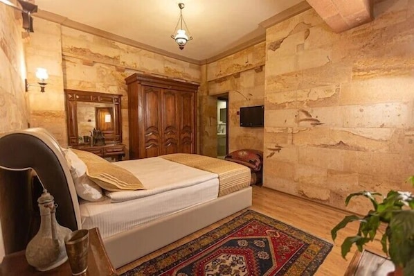 Un dormitorio con cama, armario de madera y espejo.