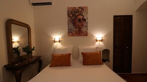 A hotel room with a large bed, two bedside tables, a mirror, and a painting on the wall. - Hotel Villa Roseraie (Vence)