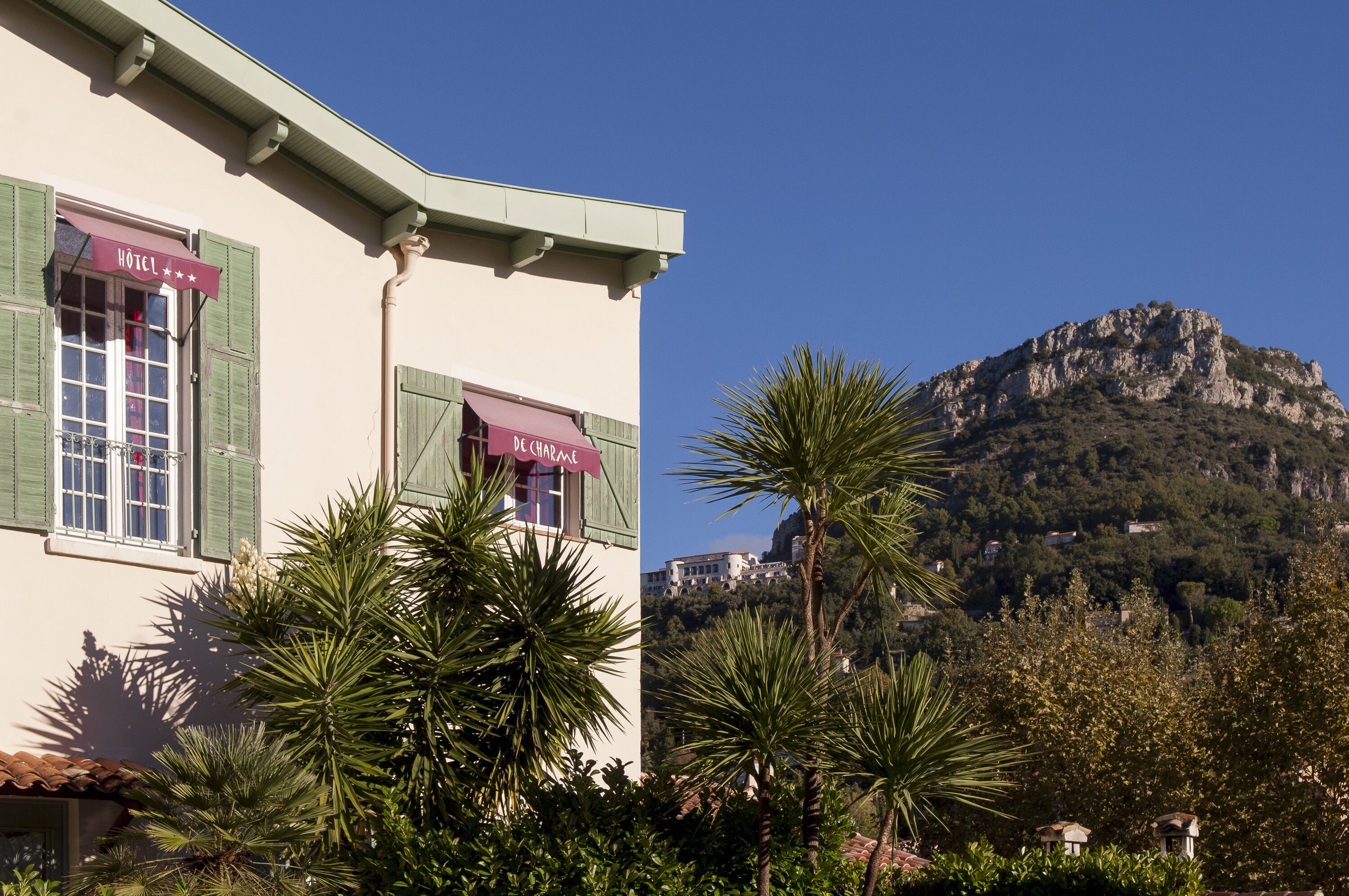 Un bâtiment sur lequel on peut lire l’inscription « HÔTEL », avec une montagne en arrière-plan.
