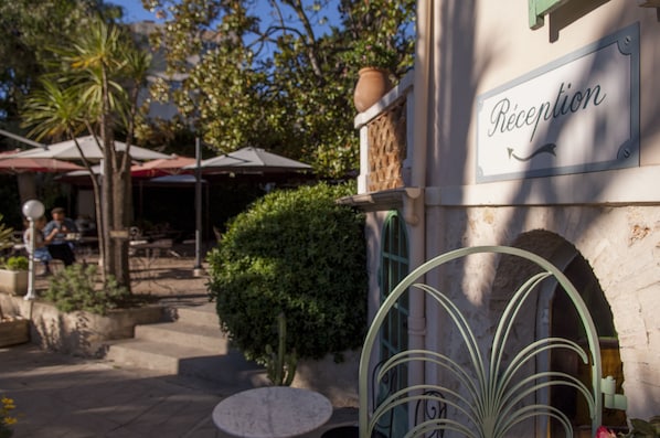 A reception area with a sign, outdoor seating, and a small table.