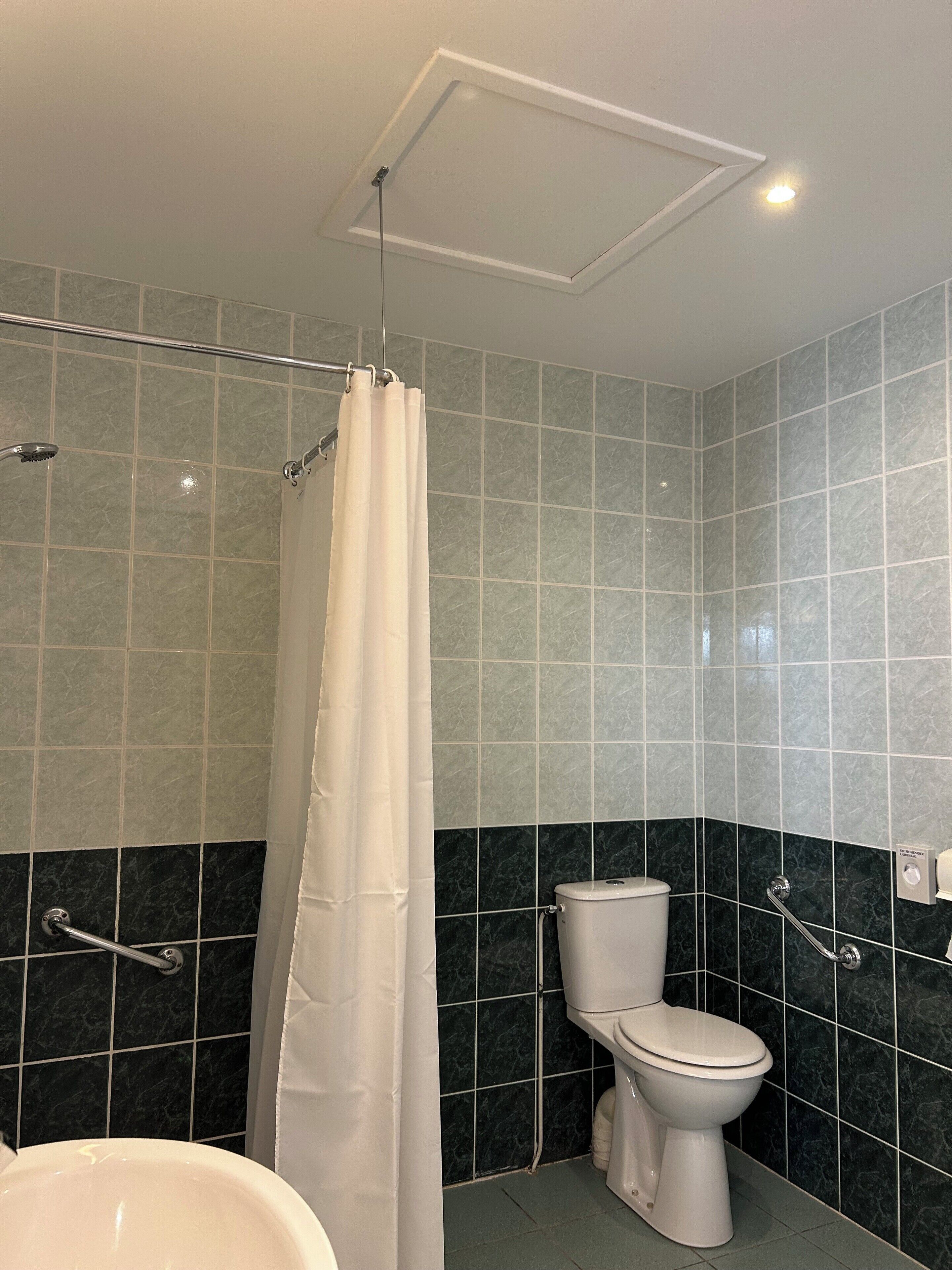 A bathroom with a shower, toilet, and sink.