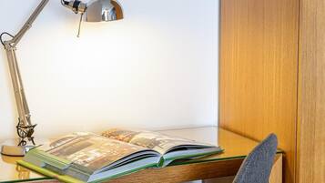 Un escritorio con una lámpara, un libro abierto y una silla.