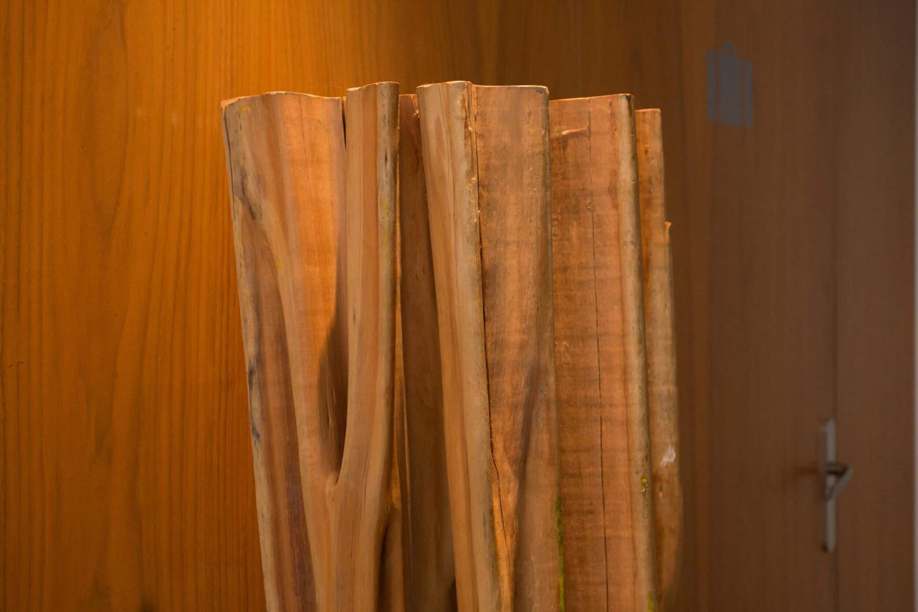 Ein Detailaufnahme von Holzdielen, die an einer Holzwand angelehnt sind.
