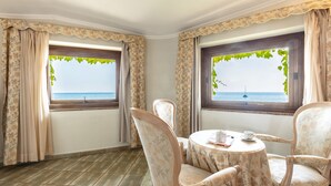 A corner room with two windows overlooking the sea, furnished with a round table and chairs. - Hotel Costa Dorada (Dorgali)