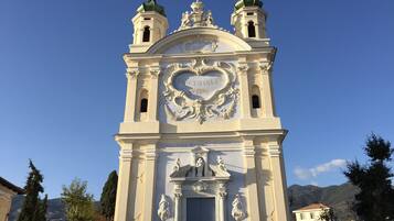 Un edificio histórico con detalles arquitectónicos ornamentales, incluyendo un reloj destacado y estatuas.