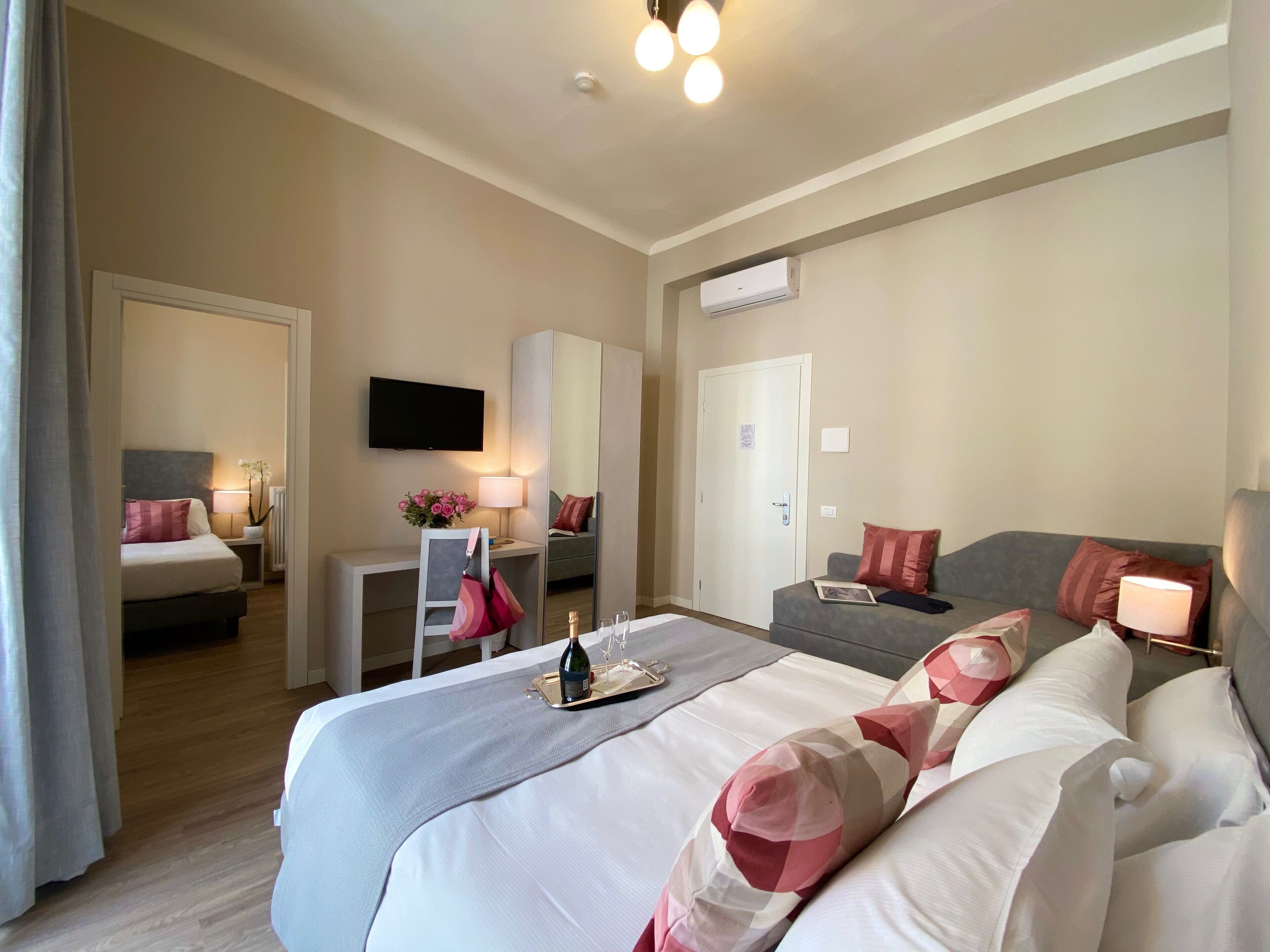 Une chambre d’hôtel avec un grand lit, un bureau, une télévision et une porte.