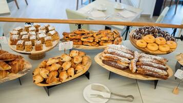 Mostrador de panadería con diversos pasteles y postres.