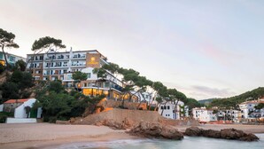 Un hotel frente al mar con varios pisos y balcones.