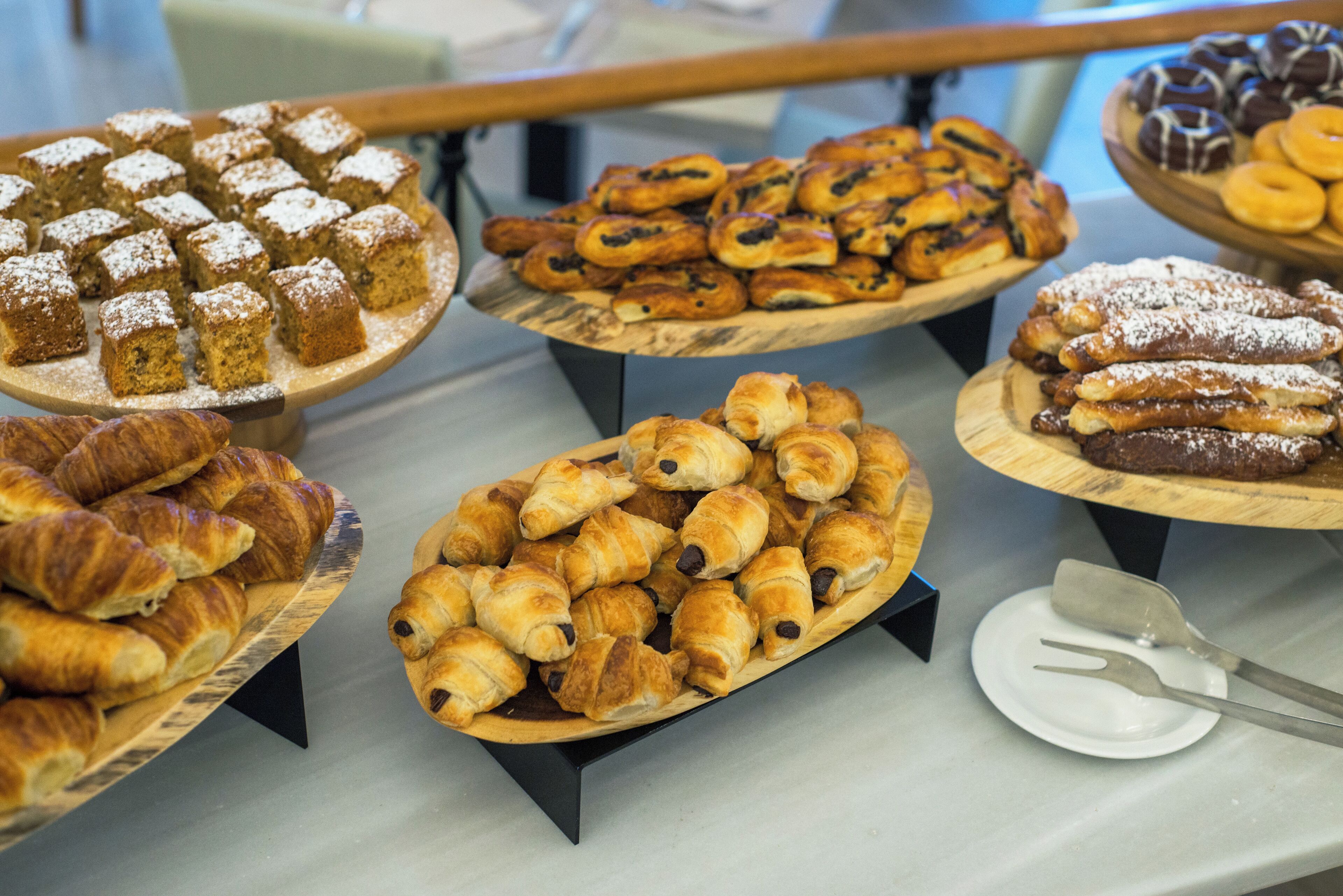 Una selezione di pasticcini esposti su supporti in legno.