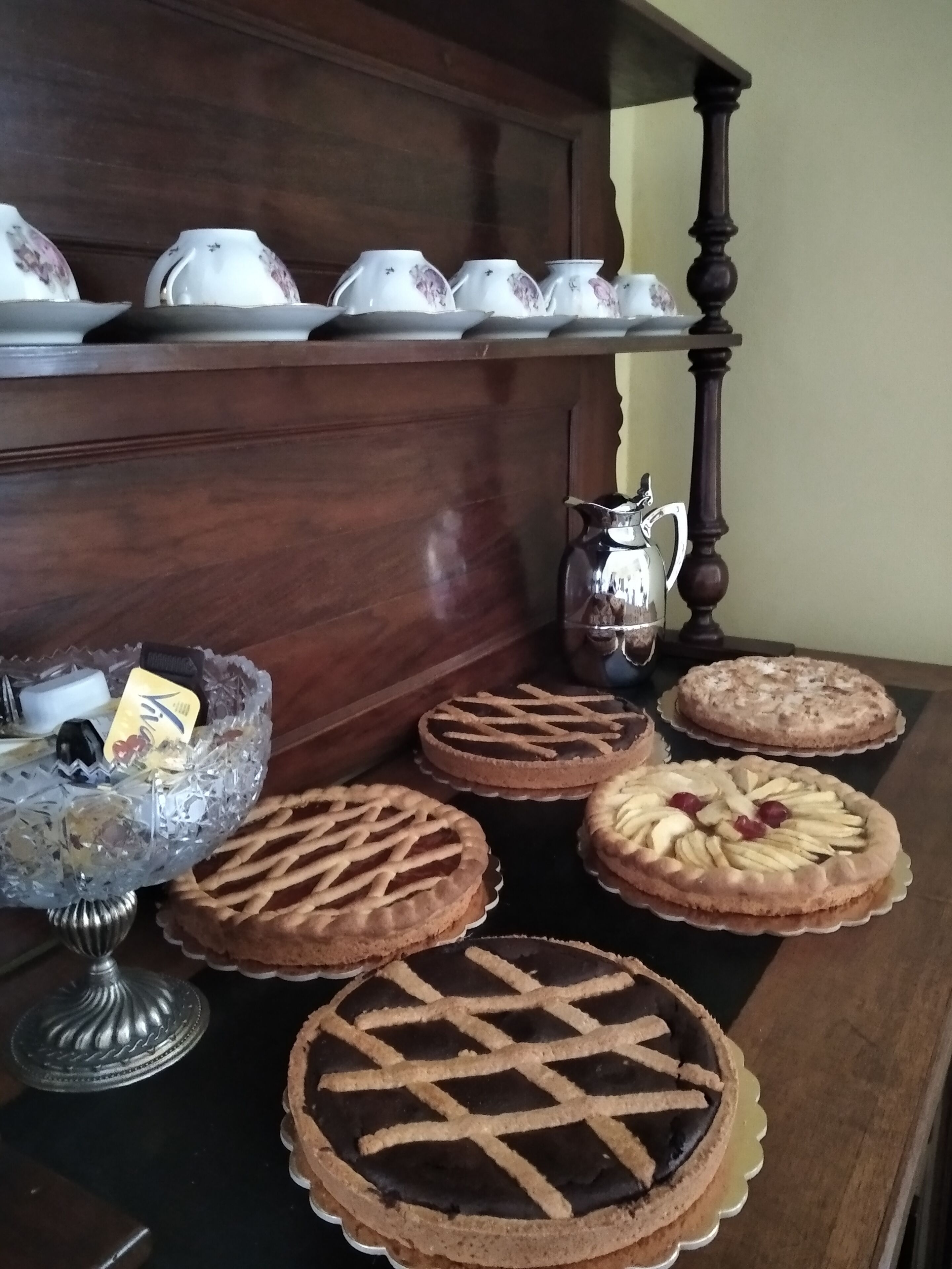 Una mesa con diversos postres y una tetera.