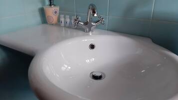 A bathroom sink with a chrome faucet and a soap dispenser.