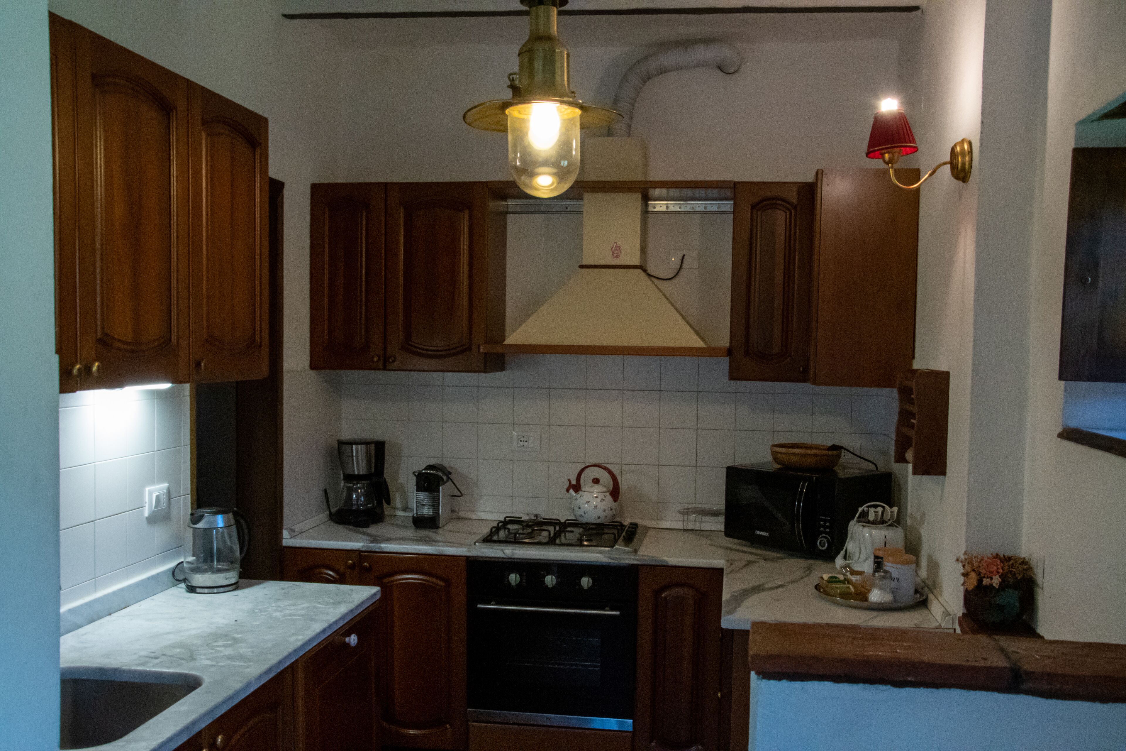 A kitchen with wooden cabinets, a stove, a microwave, and a sink.