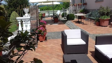 Un patio con mobiliario exterior, plantas en macetas y un camino de piedra.