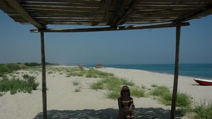 A beach scene with a wooden structure providing shade.