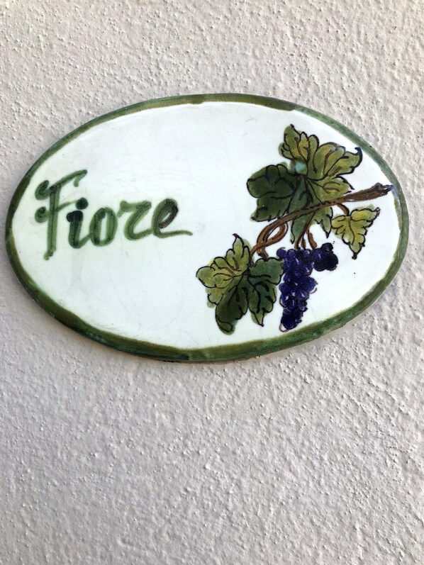 A ceramic tile with the word "Fiore" and a grapevine illustration.