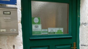 A green door with a window, a mailbox, and a TripAdvisor certificate. - Apartment Dubrovnik-Center (Dubrovnik)