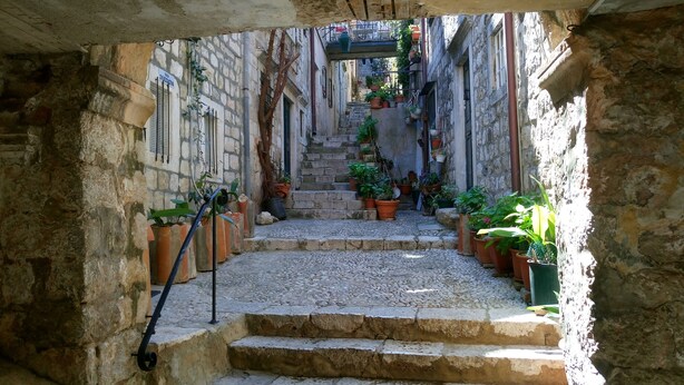 A narrow stone-paved alley with steps leading to a staircase. - Apartment Dubrovnik-Center (Dubrovnik)