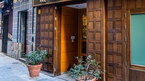 Un bâtiment sur lequel on peut lire l’inscription « El Pasaje », avec deux plantes en pot devant l’entrée.