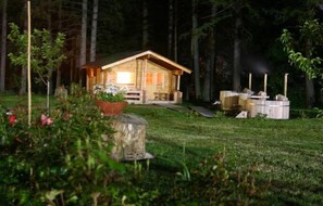 Une cabane rustique avec une façade en bois, une véranda et une cheminée.