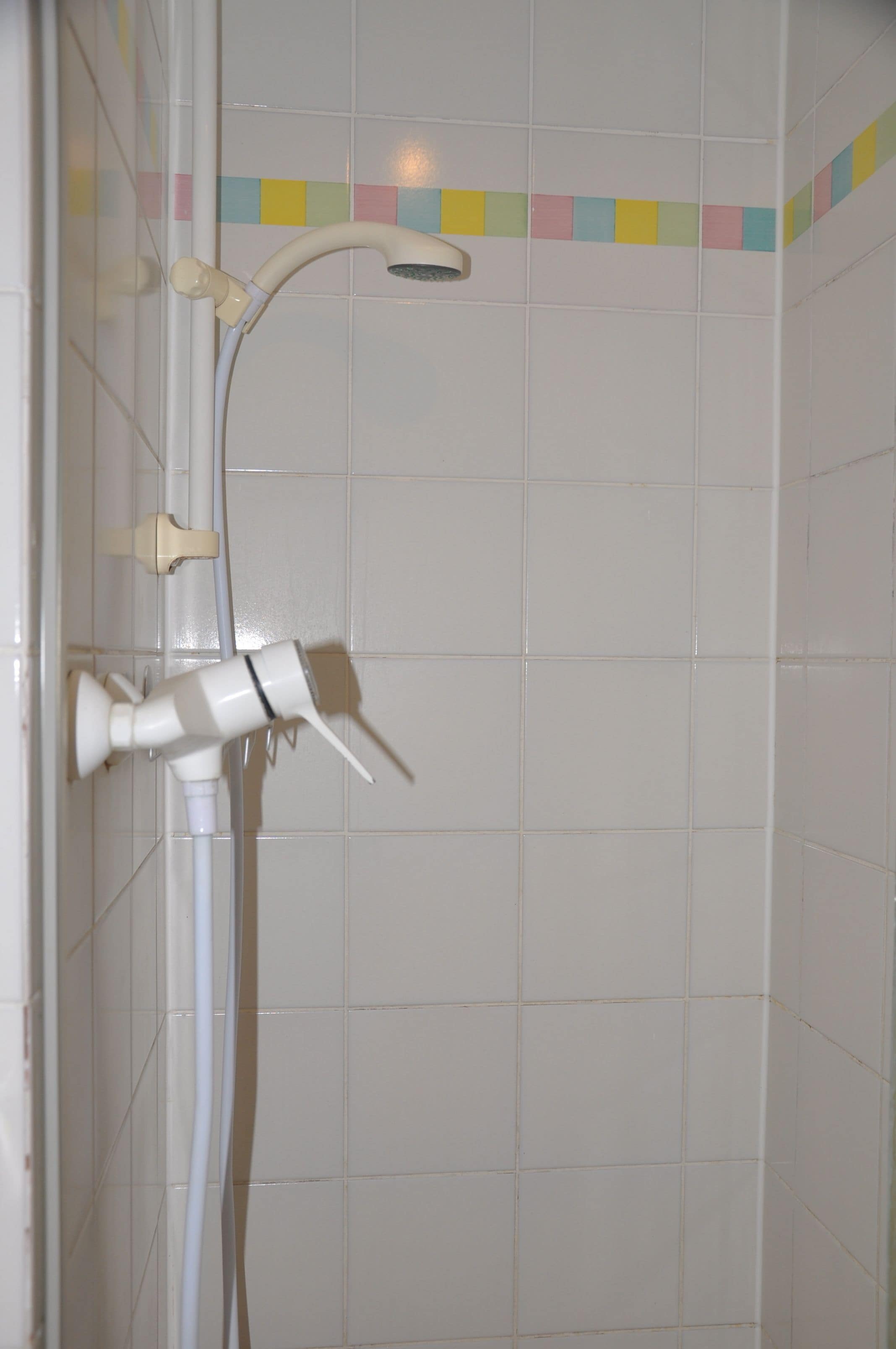 Una ducha con cabezal de ducha de mano y grifo empotrado.