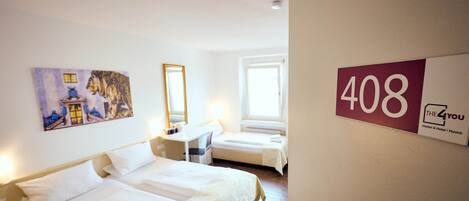 Habitación de hotel con dos camas, un escritorio, un espejo y un cuadro en la pared. El número de habitación es 408.