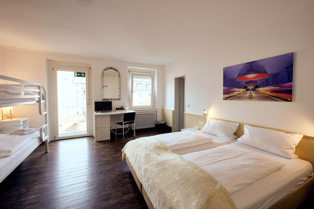 Ein Hotelzimmer mit Bett, Schreibtisch, Stuhl und Tür.