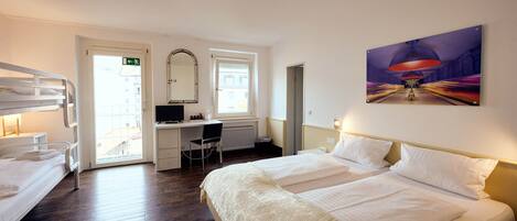 Una habitación de hotel con cama, escritorio, silla y puerta.