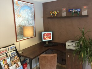 Ein Hotelrezeptionstresen mit Computer, einer Karte und einer Pflanze.