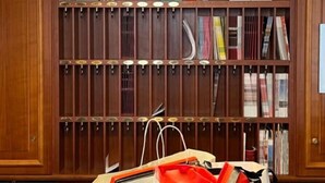 A bookstore with wooden shelves, a clock, and hanging pendant lights. - Boutique Hotel Kugel Wien (Vienna)