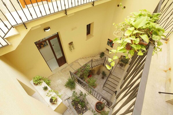 A multi-level courtyard with potted plants and a staircase.