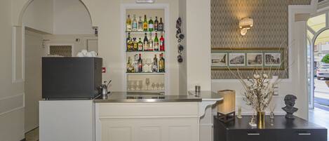 A bar area with a minibar, shelves of liquor bottles, and a decorative wall with a patterned wallpaper.