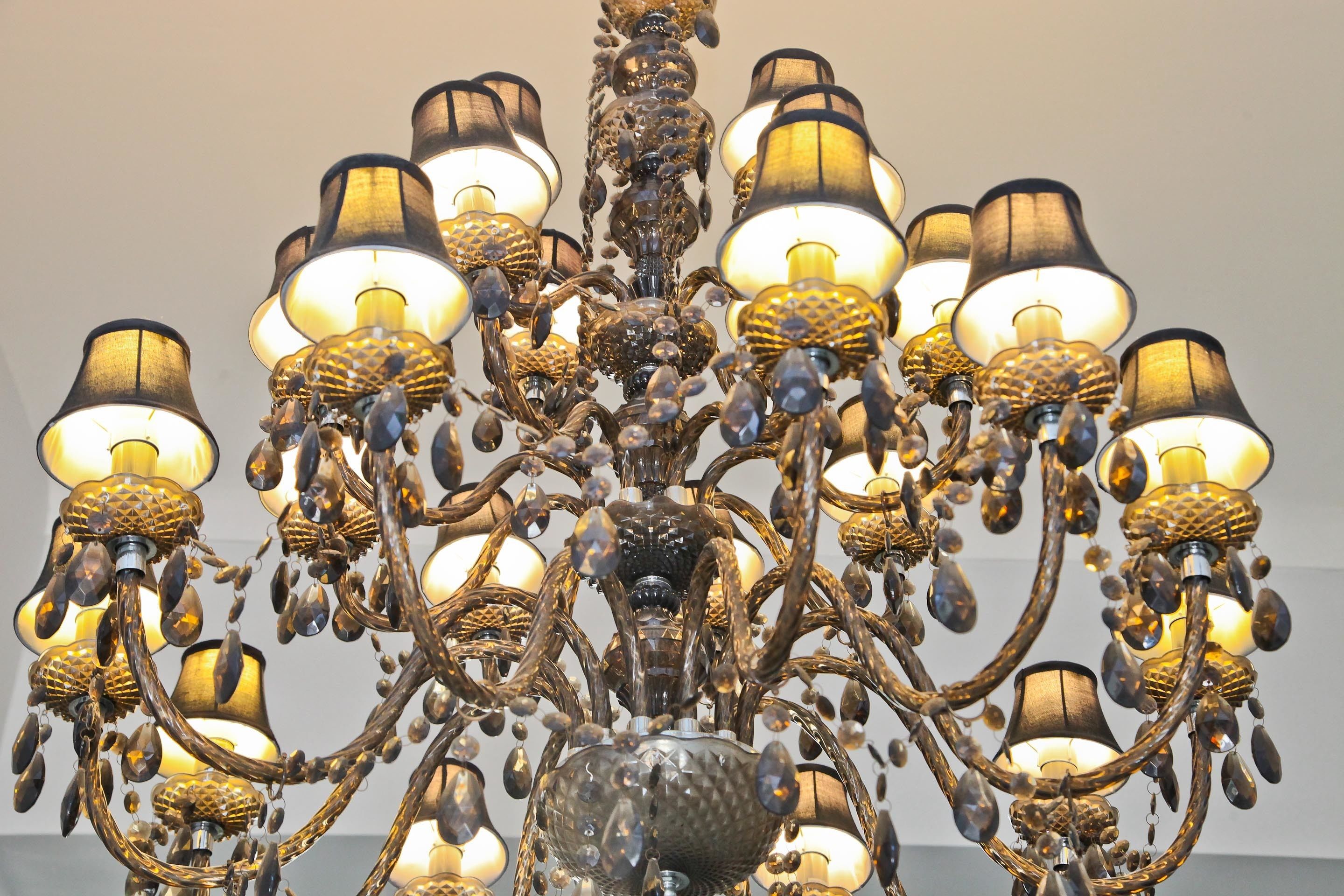 Um candelabro com várias luminárias e detalhes decorativos.
