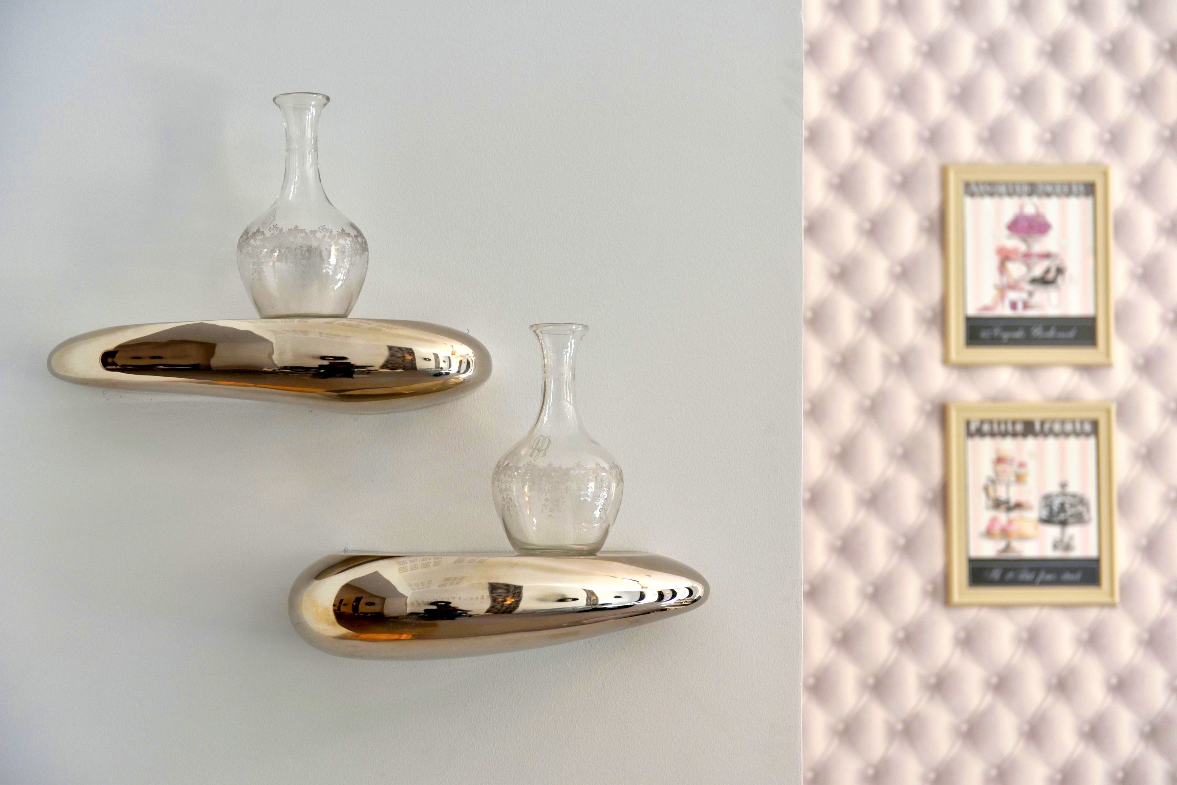 Two wall-mounted vases and two framed pictures on a wall.