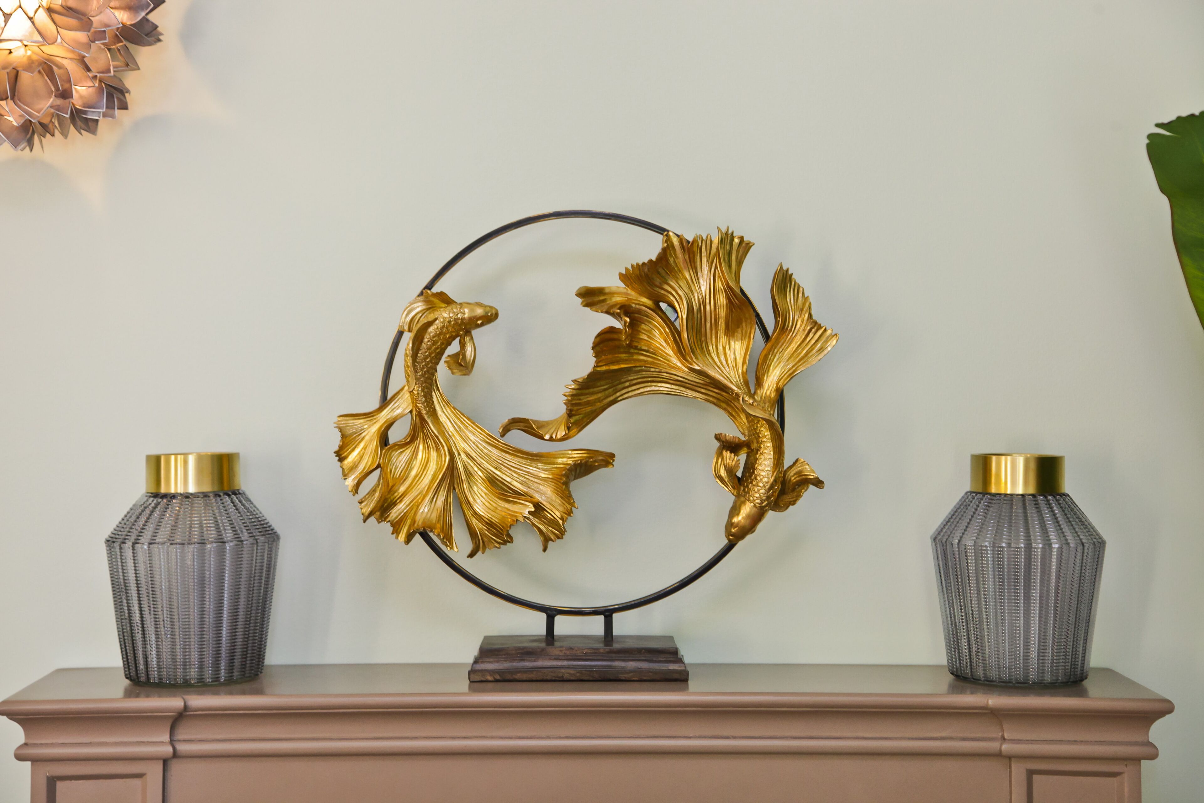A decorative wall piece with two vases on a dresser.