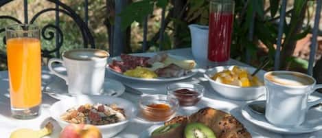 Uma mesa posta para o café da manhã, com diversos alimentos, bebidas e utensílios.
