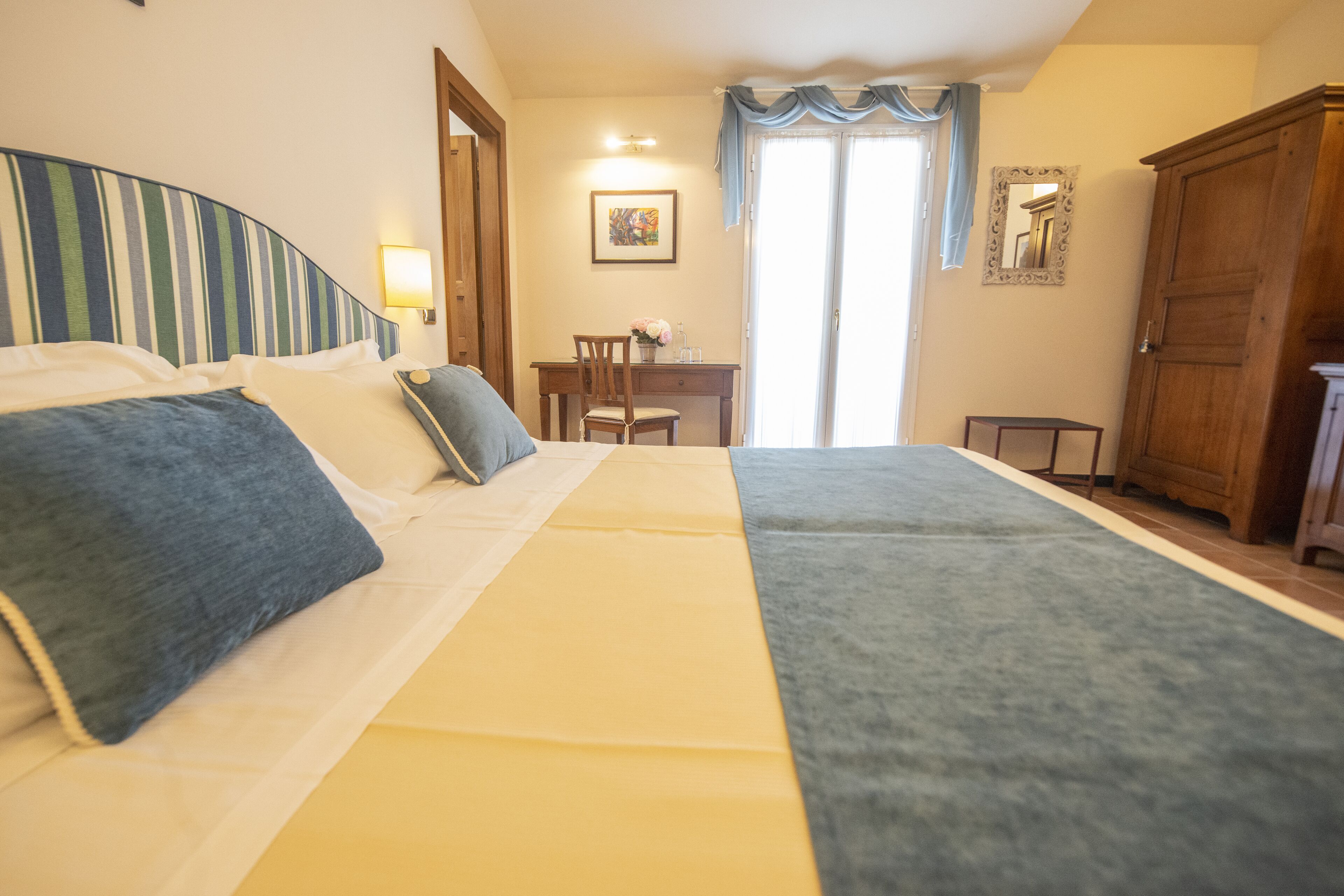 Una habitación de hotel con dos camas, un escritorio, una silla y un armario.
