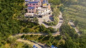 Eine Vogelperspektive auf ein Resort mit Swimmingpool, mehreren Gebäuden und üppiger Vegetation.